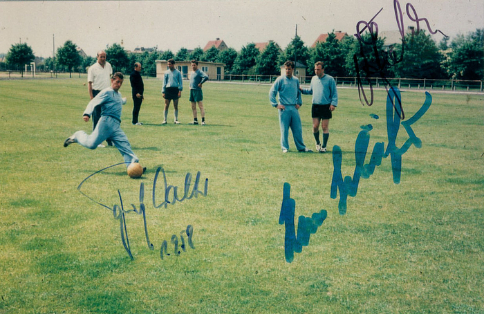 Farbreprofoto vom Traingsplatz der deutschen Nationalmanschaft bei der Fußball Weltmeisterschaft 1958 mit original Signaturen von Fritz Walter, Hans Schäfer und Uwe Seeler, 15x10 cm.