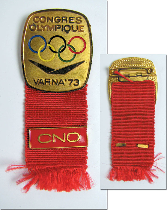 Teilnehmer-Abzeichen der IOC Session Varna 1973. Bronze, vergoldet, mit rotem Bändchen und Plakette "CNO" emailliert. Abzeichen 3,3x2,8 cm.
