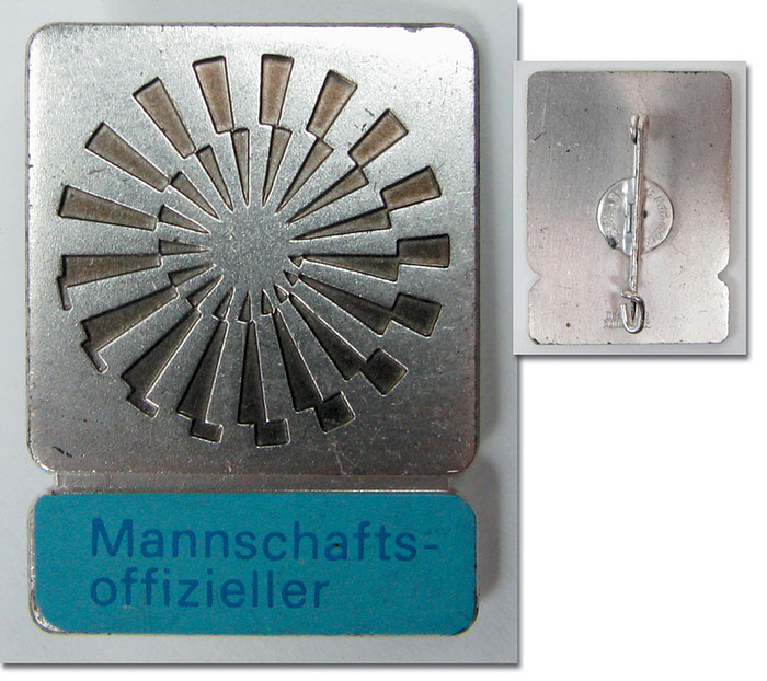 Offizielles Teilnehmerabzeichen für die Olympischen Spiele München 1972: „Mannschaftsoffzieller“. Bronze, versilbert, hellblaue Schriftleiste. 3,5x2,5 cm.
