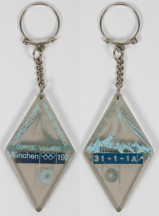 Original Schlüsselanhänger der Oympischen Spiele München 1972 für das Olympische Dorf. Mit der Silhouette des Olympiastadions und der Aufschrift "Olympischen Dorf Village Olympique Olympic Village. München 1972. Plexiglas, bedruckt, 7x4 cm. Schlüsselanhänger mit original Zimmernummern!.