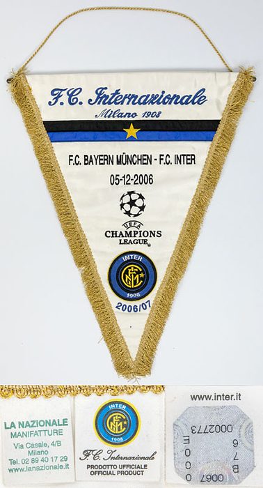 Original bestickter Spielwimpel "F.C. Internaionale Milano 1908. FC Bayern München - F.C. Inter  05-12-2006. UEFA Champions League 2006 - 2007" mit aufgestickten Schriftzügen und aufgenähtem gesticktem Vereinsemblem von Inter. Weißer Seidenwimpel mit Goldbrokatfransen, Goldbrokatkordel und Metallstange. 43x35 cm.