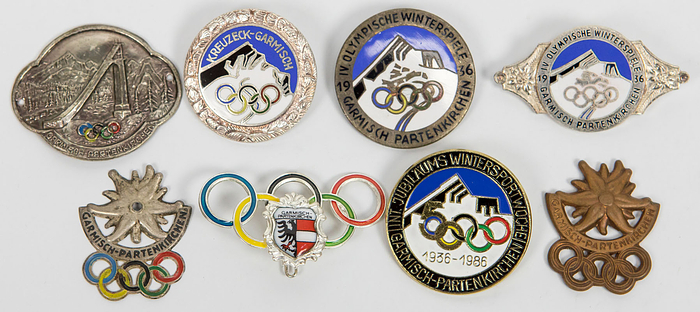 8 verschiedene Abzeichen zu den Olympischen Winterspielen Garmisch-Partenkrichen 1936. 4,5x2,5 bis 3x3 cm.