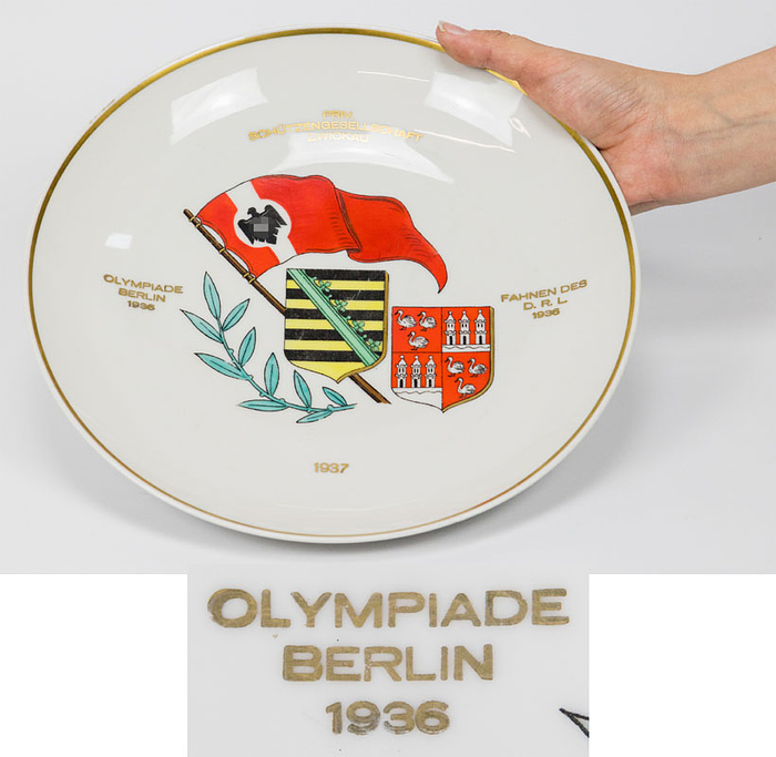 Erinnerungsteller der "Priv. Schützengesellschaft Zwickau 1937" mit der zusätzlichen Aufschrift "Olympiade Berlin 1936 - Fahnen des DRL 1936". Handbemalt!. Thüringer Porzellan, Durchmesser, 26,5 cm.