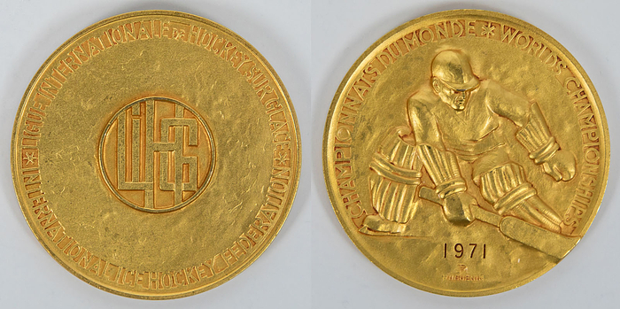 Goldmedaille der Eishockey - Weltmeisterschaften 1971 in Bern /Genf mit der Inschrift „Championnat du Monde. World Championship" und der Gravur "1971“. Bekamen die Spieler der UdSSR für den Weltmeister Titel. Hersteller: "Hugenin". Bronze, vergoldet, 6 cm.