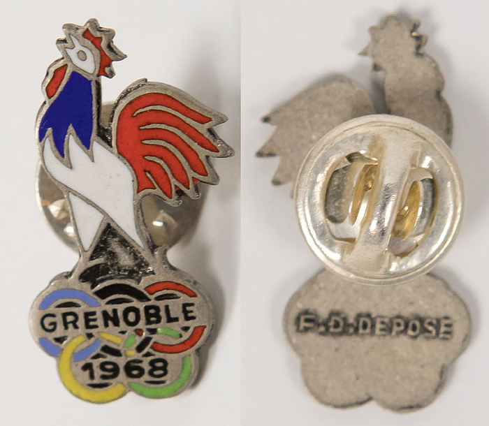 „Grenoble 1968“. Offizielles Mannschaftsabzeichen von Frankreich für die Olympischen Winterspiele 1968. Bronze, versilbert, farbig emailliert. 3x2 cm.