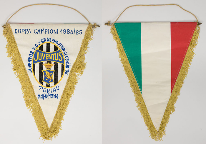 Originalspielwimpel Juventus Turin mit aufgesticktem Schriftzug „Coppa Campioni 1984/85 Juventus F.C. (Turin) v Grasshoppers Club Zürich  Torino  24 / 10 / 1984“ (2:0) mit aufgesetztem bestickten Vereinslogo. Rückseite in Nationalfarben Italiens. Leinenwimpel mit Seidenfransen. Metallstange. 42x32 cm.