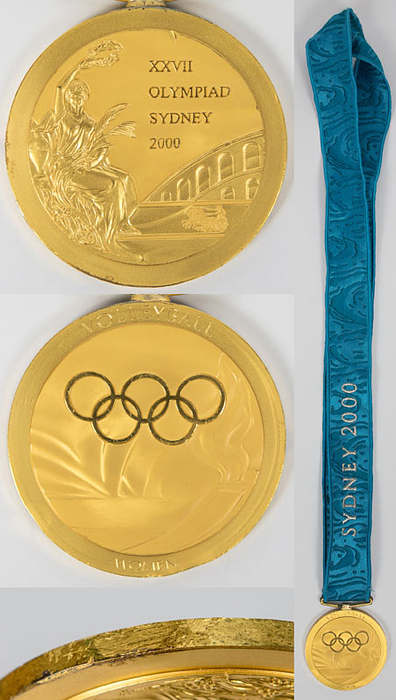 Goldmedaille für den 1.Platz im Volleyball der Frauen für Kuba bei den Olympischen Spielen Sydney 2000. Silber, vergoldet mit Gravur "Volleyball Women". Original besticktem Seidenband, 6,8 cm.