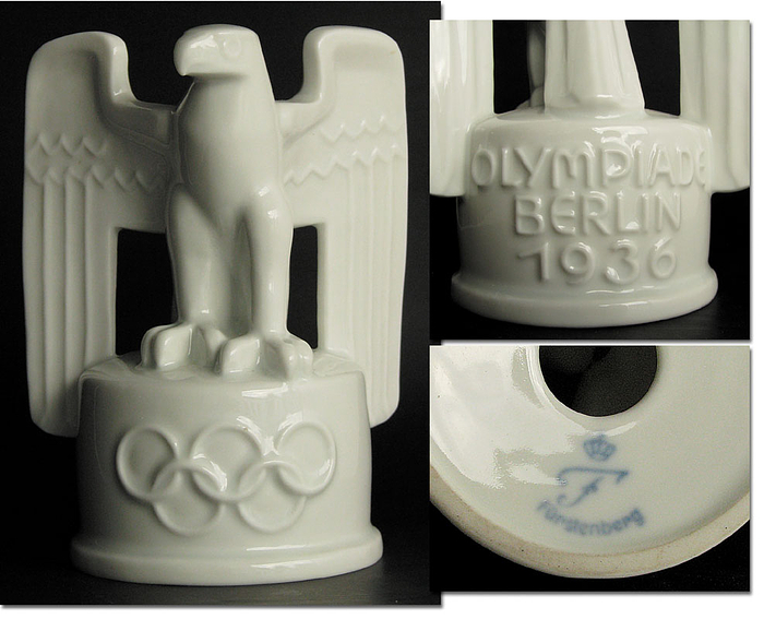 Sehr schöne Porzellanfigur der Firma „Fürstenberg“. Adler auf Sockel über Olympische Ringe. Mit Sockelaufschrift „Olympiade Berlin 1936“. 12x10 cm.