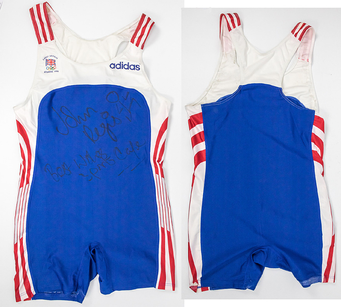 Original worn Sprinter body von den Olympischen Spielen 1996 in Atlanta. Getragen von John Regis im Semi Finale des 200m Sprint (Fotomatched). Regis ist ausgeschieden. Regis ist Bronze-Gewinner 1982 bei der 4x100m Staffel und Silbermedaillen-Gewinner 1988 und Goldmedaillen-Gewinner 1989 im 200m WM-Lauf. Mit original Autograph und Widmung von John Regis auf der Vorderseite. Status:AAC.