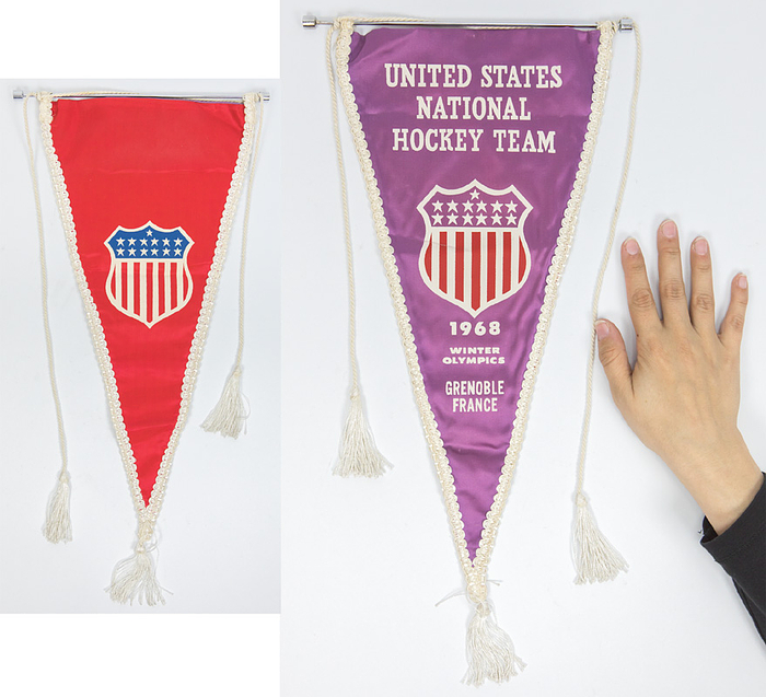 Original Spielwimpel der Eishockeymannschaft der USA für die Olympischen Winterspiele Greoble 1968. Mit dem Aufdruck "Unitd States National Hockey team 1968 Winter Olympics Grenoble France". Seidenwimpel mit weißer Seidenbordüre und drei Seidenbommeln. Edelstahlstange. Rückseite mit dem Logo der USA Olymiamannschaft, 42x20 cm (ohne Bommel).