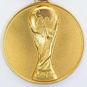 Offizielle Siegermedaille der deutschen Fußball-Nationalmannschaft für den Sieg bei der Fußball-Weltmeisterschaft 1990 in Italien. Coupe du monde de la FIFA Italie 1990“ Gold (gepunzt, 585er, Gewicht: 78 Gramm) mit original, dreifarbigem Seidenband. Hersteller: Hugenin. 5 cm. Persönliches Exemplar des Fußball Weltmeisters Thomas Häßler. Häßler bestätigt mit einem Echtheitszertifikat (COA), dass dieses Stück aus seiner Sammlung gekommen ist. - Bild 2