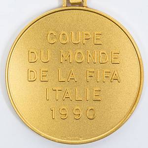 Offizielle Siegermedaille der deutschen Fußball-Nationalmannschaft für den Sieg bei der Fußball-Weltmeisterschaft 1990 in Italien. Coupe du monde de la FIFA Italie 1990“ Gold (gepunzt, 585er, Gewicht: 78 Gramm) mit original, dreifarbigem Seidenband. Hersteller: Hugenin. 5 cm. Persönliches Exemplar des Fußball Weltmeisters Thomas Häßler. Häßler bestätigt mit einem Echtheitszertifikat (COA), dass dieses Stück aus seiner Sammlung gekommen ist. - Bild 3