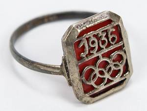 Ring OSS1936  | Ring anlässlich der Olympischen Spielen Berlin 1936 Olympischen Ringen und der Inschrift "1936". versilbert, Ringdurchmesser 20mm. Versilbert mit Bernsteinimitat. Bildseite: 1,5x1,1 cm. - Bild 2