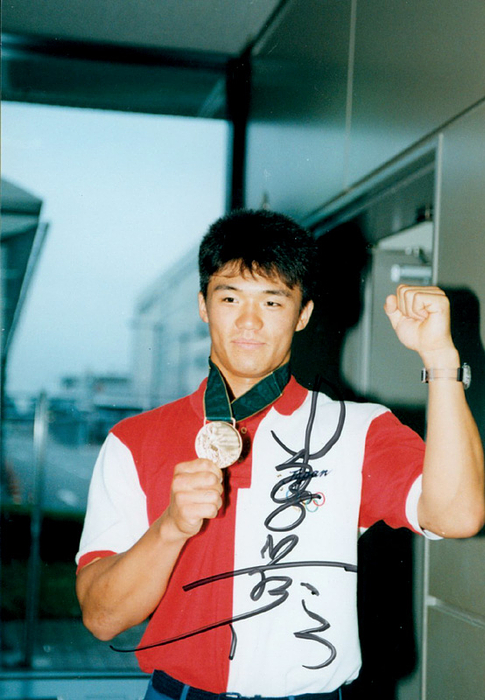 Jumonji, Takanobu  | Farbfoto mit original Signatur von Takanobu Jumonji (JPN). Bronzemedaille im Radsport bei den Olympischen Spielen 1996 im 1000m Zeitfahren. 12,5x9,5 cm