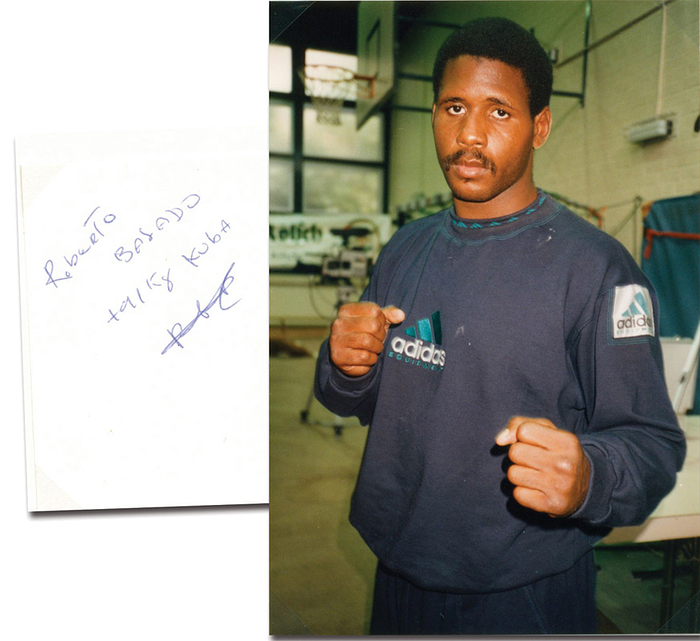 Balado Méndez, Roberto  | (1969-1994) Karteikarte mit original Signatur von Roberto Balado Méndez (CUB) und einem aufmontierten Farbfoto. Goldmedaille im Boxen Superschwergewicht bei den Olympischen Spielen 1992. 3facher Weltmeister von 1989 - 1993. DIN A4 Sammlerkarton mit Fotoecken montiert