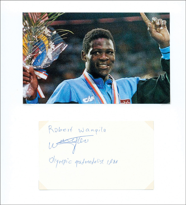  - File card with original signature of Robert Wangila (1967-1994). The Kenian boxer won the welterweight gold medal in the 1988 Olympics. 12.7 x 7.7 cm. Mounted on 29.7 x 21 cm ablum sheet using photo corners. Condition: A