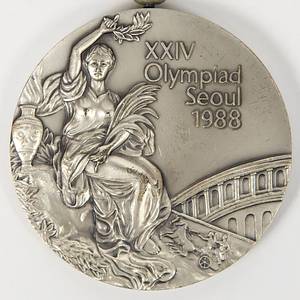 Olympic Games Seoul 1988. Silver Winner medal - Olympic Games Seoul 1988. Silver Winner medal: Original winner's medal from the 1988 Seoul Olympic Games for second place in the equestrian dressage team for Switzerland. Engraved with "Equestrian Team Dressage" on the edge. Silver, 6 cm (weight 140), with original silk ribbon. --The consignor received this medal directly from the Swiss athlete. The buyer will receive the athlete's name. Condition: A - Bild 2
