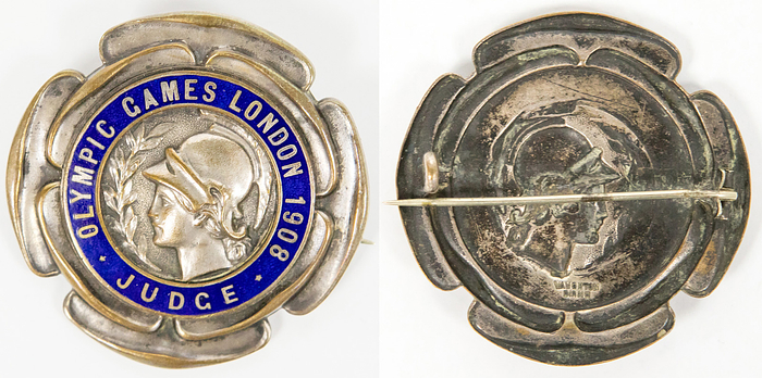 Teilnehmerabzeichen 1908  | Offizielles Teilnehmerabzeichen für die Olympischen Spiele 1908 in London mit der Aufschrift "Olympic Games London 1908 Judge" (Jury).  Bronze, versilbert, blau emailliert, Hersteller: "Vaughton,Birmingham", 5,7 cm.