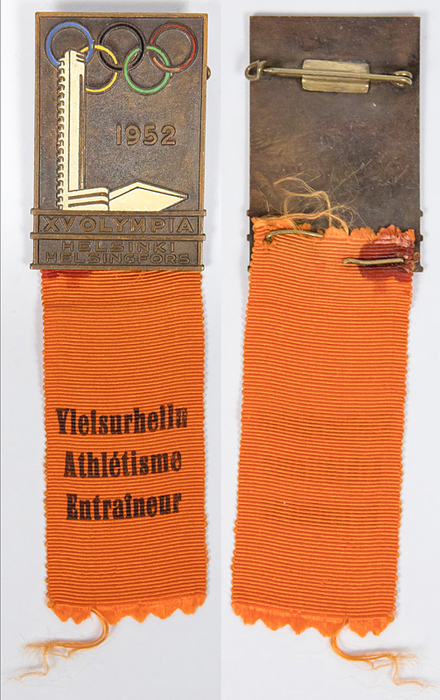 Teilnehmerabzeichen 1952  | Teilnehmerabzeichen „Yletsurhellu Athletisme Entrainuer“ (Trainer Leihtathetik) für die Olympischen Spiele Helsinki 1952. Bronze, mehrfarbig emailliert. Mit orangenem bedrucktem Seidenband, 11,5x3,3 cm.