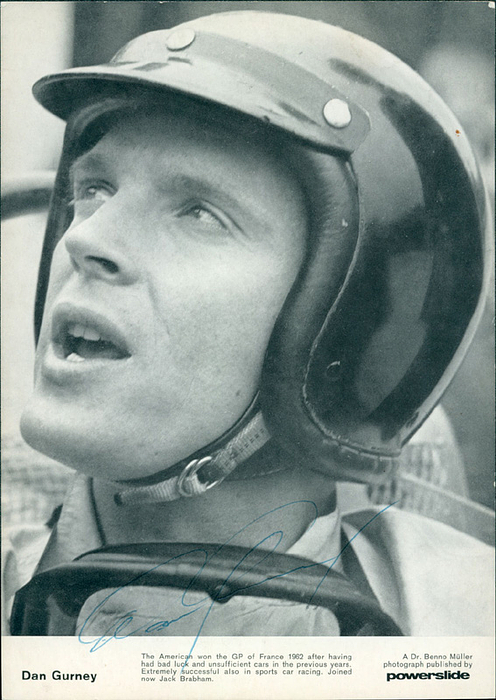 - (1931-2018) Black and white autogrammcard (Powerslide) with original signature of Dan Gurney in a 1961/62 Porsche. US-American automobile and Formula 1 racing driver and designer. World Championship fourth place finisher in 1961 and 1965, 21x15 cm Condition: B+
