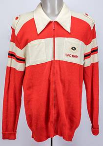 Köln, 1.FC - Jacke + Hose 1968  | 1) Freizeitjacke des 1.FC Köln von Heinz Simmet für die Spieler der Bundesligamannschaft ca. 1968. Schurwolle, rot-weiß; mit aufgeflockten Schriftzug "1.FC Köln" auf der Brusttasche. Größe 56. Hersteller: "Carlo Gruber", Logo von Gruber auf der Brusttasche aufgenäht. Roter Reisverschluss; geknöpfte Schulterriemchen mit roten Knöpfen. Museumsstück! 2) Offizielle schwarze Anzugshose des 1.FC Köln von Heinz Simmet von adidas. 70%Polyacryl - 30% Schurwolle. Größe 50. Hersteller Schwahn/adidas. Status:ACC. - Bild 2