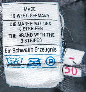 Köln, 1.FC - Jacke + Hose 1968  | 1) Freizeitjacke des 1.FC Köln von Heinz Simmet für die Spieler der Bundesligamannschaft ca. 1968. Schurwolle, rot-weiß; mit aufgeflockten Schriftzug "1.FC Köln" auf der Brusttasche. Größe 56. Hersteller: "Carlo Gruber", Logo von Gruber auf der Brusttasche aufgenäht. Roter Reisverschluss; geknöpfte Schulterriemchen mit roten Knöpfen. Museumsstück! 2) Offizielle schwarze Anzugshose des 1.FC Köln von Heinz Simmet von adidas. 70%Polyacryl - 30% Schurwolle. Größe 50. Hersteller Schwahn/adidas. Status:ACC. - Bild 8