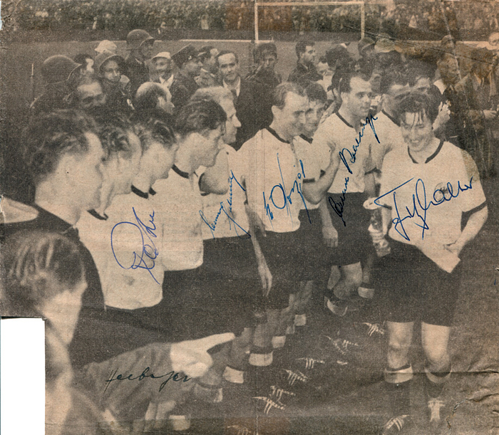 WM 1954 Autographen  | s/w-Zeitungsbild mit den Originalsignaturen der Weltmeister von 1954  Werner Kohlmeyer (1924-1974), Fritz Walter (1920-2002), Josef Posipal (1927-1997), Werner Liebrich (1935-1993), Helmut Rahn (1929-2003) und Sepp Herberger (1897-1977). 21,6x19 cm.