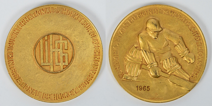 Siegermedaille 1965  | Goldmedaille der Eishockey - Weltmeisterschaften 1965 in Tampere mit der Inschrift „Championnat du Monde. World Championship" und der Gravur "1965“. Bekamen die Spieler der UdSSR für den Weltmeister Titel. Hersteller: "Hugenin". Bronze, vergoldet, 6 cm.