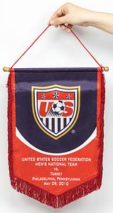 USA - Spielwimpel 2010  | Original Spielwimpel der Fußball - Nationalmannschaft der USA. Seidenbedruckter Wimpel mit Aufschrift "United States Soccer Federation. Men´s National Team vs Turkey. Philadelphia, Pensylvania. May 29, 2010" (1:2). Vergoldete Holzkugeln mit Holzstange. Rote Seidenfransen. 43x29 cm. - Bild 2