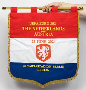 Niederlande-Spielwimpel 2024  | Offizieller originaler Tauschspielwimpel der Nationalmannschaft der Niederlande für das Gruppenspiel bei der UEFA Euro 2024 mit der aufgestickten Inschrift in Goldbrokat "UEFA Euro 2024 The Netherlands v Austria. 25 June 2024 Olympiastadion Berlin" (Niederlande v Österreich 2:3). Dreifarbiger Stoffleinenwimpel  und aufgesetztem, besticktem Verbandsemblem der Niederlande. Mit gelben Seidenfransen, vergoldete Leichtmetallstange mit zwei Kunststoffkugeln. 50x43 cm. Bei diesem Exemplar handelt es sich um den Wimpel den die Mannschaftskapitäne im Mittelkreis vor Spielbeginn getauscht haben. - Bild 2
