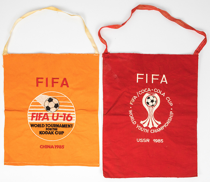  - Two FIFA pennants: "FIFA U-16 World Tournament China 1985" and "World Youth Championships 1985 USSR". Embroidered linen pennants, approx. 30 x 22.5 cm. Condition: B-