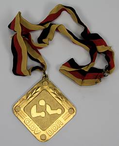  - Two winner's medals from the 1979 and 1980 East German Boxing Championships: 1) Gold medal inscribed "1979 East German Championship Senior Featherweight" with silk ribbon. 2) Bronze medal "1980 East German Championship Senior Light Middleweight" with silk ribbon. Each 8x8 cm in original box. Also included: an honorary plaque of the German Boxing Association (DBV) - East Germany with the inscription "Honorary Plaque Gerd Lang" on the reverse. Gilt bronze with an applied, enameled state coat of arms, 8.5x8.5 cm. --signs of usage Condition: B - Bild 2