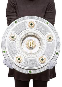 DFB-Meisterschale 2024 Bayer Leverkusen  | Offizielles Replikat der DFB-Meisterschale für die Saison 2023/24 für den deutschen Meister 2024 Bayer Leverkusen. Der jeweilige deutsche Meister hat das Recht Replikas in dieser Größe offiziell anfertigen zulassen.  Letzte Inschrift auf der Schale "Bayer Leverkusen 2024". Versilbert, Messing, ziervergoldet, Gravuren. Hersteller: Koch & Bergfeld, Bremen. Gewicht: 6,6 kg, Durchmesser 52 cm. Mit original Koffer, innen mit geprägtem DFB-Logo. 59x59x18cm. Mit original Signaturen von Xabi Alonso, Florian Wirtz, Jonathan Tah und Robert Andrich. Weil die Spieler von Bayer Leverkusen von ihrem Trainer Xabvi Alsonso anläßlich der Deutschen Fußballmeisterschaft eine kleine Meisterschale (ca. 18 cm) aus Silber bekamen, machte keiner der Spieler von seinem Recht  gebrauch sich von der Firma Koch & Bergfeld eine fast 1:1 Kopie der orignal Meisterschale anfertigen zu lassen. Es wurden laut Aussagen des Einlieferes lediglich zwei Exemplare produziert. Ein Exemplar befindet sich im Museum / Klubräumen von Bayer Leverkusen in der BayArena. Das andere Exemplar wird in dieser Auktion angeboten. Mit original Plexiglasständer für diese Meisterschale. EIN HIGHLIGHT FÜR JEDE SAMMLUNG!. - Bild 2