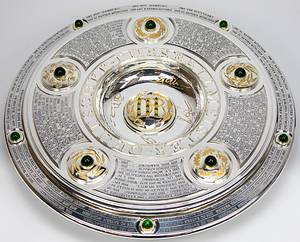 DFB-Meisterschale 2024 Bayer Leverkusen  | Offizielles Replikat der DFB-Meisterschale für die Saison 2023/24 für den deutschen Meister 2024 Bayer Leverkusen. Der jeweilige deutsche Meister hat das Recht Replikas in dieser Größe offiziell anfertigen zulassen.  Letzte Inschrift auf der Schale "Bayer Leverkusen 2024". Versilbert, Messing, ziervergoldet, Gravuren. Hersteller: Koch & Bergfeld, Bremen. Gewicht: 6,6 kg, Durchmesser 52 cm. Mit original Koffer, innen mit geprägtem DFB-Logo. 59x59x18cm. Mit original Signaturen von Xabi Alonso, Florian Wirtz, Jonathan Tah und Robert Andrich. Weil die Spieler von Bayer Leverkusen von ihrem Trainer Xabvi Alsonso anläßlich der Deutschen Fußballmeisterschaft eine kleine Meisterschale (ca. 18 cm) aus Silber bekamen, machte keiner der Spieler von seinem Recht  gebrauch sich von der Firma Koch & Bergfeld eine fast 1:1 Kopie der orignal Meisterschale anfertigen zu lassen. Es wurden laut Aussagen des Einlieferes lediglich zwei Exemplare produziert. Ein Exemplar befindet sich im Museum / Klubräumen von Bayer Leverkusen in der BayArena. Das andere Exemplar wird in dieser Auktion angeboten. Mit original Plexiglasständer für diese Meisterschale. EIN HIGHLIGHT FÜR JEDE SAMMLUNG!. - Bild 3