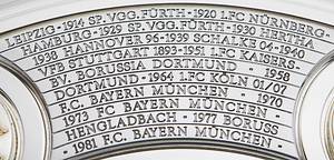 DFB-Meisterschale 2024 Bayer Leverkusen  | Offizielles Replikat der DFB-Meisterschale für die Saison 2023/24 für den deutschen Meister 2024 Bayer Leverkusen. Der jeweilige deutsche Meister hat das Recht Replikas in dieser Größe offiziell anfertigen zulassen.  Letzte Inschrift auf der Schale "Bayer Leverkusen 2024". Versilbert, Messing, ziervergoldet, Gravuren. Hersteller: Koch & Bergfeld, Bremen. Gewicht: 6,6 kg, Durchmesser 52 cm. Mit original Koffer, innen mit geprägtem DFB-Logo. 59x59x18cm. Mit original Signaturen von Xabi Alonso, Florian Wirtz, Jonathan Tah und Robert Andrich. Weil die Spieler von Bayer Leverkusen von ihrem Trainer Xabvi Alsonso anläßlich der Deutschen Fußballmeisterschaft eine kleine Meisterschale (ca. 18 cm) aus Silber bekamen, machte keiner der Spieler von seinem Recht  gebrauch sich von der Firma Koch & Bergfeld eine fast 1:1 Kopie der orignal Meisterschale anfertigen zu lassen. Es wurden laut Aussagen des Einlieferes lediglich zwei Exemplare produziert. Ein Exemplar befindet sich im Museum / Klubräumen von Bayer Leverkusen in der BayArena. Das andere Exemplar wird in dieser Auktion angeboten. Mit original Plexiglasständer für diese Meisterschale. EIN HIGHLIGHT FÜR JEDE SAMMLUNG!. - Bild 6