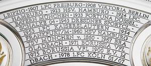 DFB-Meisterschale 2024 Bayer Leverkusen  | Offizielles Replikat der DFB-Meisterschale für die Saison 2023/24 für den deutschen Meister 2024 Bayer Leverkusen. Der jeweilige deutsche Meister hat das Recht Replikas in dieser Größe offiziell anfertigen zulassen.  Letzte Inschrift auf der Schale "Bayer Leverkusen 2024". Versilbert, Messing, ziervergoldet, Gravuren. Hersteller: Koch & Bergfeld, Bremen. Gewicht: 6,6 kg, Durchmesser 52 cm. Mit original Koffer, innen mit geprägtem DFB-Logo. 59x59x18cm. Mit original Signaturen von Xabi Alonso, Florian Wirtz, Jonathan Tah und Robert Andrich. Weil die Spieler von Bayer Leverkusen von ihrem Trainer Xabvi Alsonso anläßlich der Deutschen Fußballmeisterschaft eine kleine Meisterschale (ca. 18 cm) aus Silber bekamen, machte keiner der Spieler von seinem Recht  gebrauch sich von der Firma Koch & Bergfeld eine fast 1:1 Kopie der orignal Meisterschale anfertigen zu lassen. Es wurden laut Aussagen des Einlieferes lediglich zwei Exemplare produziert. Ein Exemplar befindet sich im Museum / Klubräumen von Bayer Leverkusen in der BayArena. Das andere Exemplar wird in dieser Auktion angeboten. Mit original Plexiglasständer für diese Meisterschale. EIN HIGHLIGHT FÜR JEDE SAMMLUNG!. - Bild 9