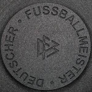 DFB-Meisterschale 2024 Bayer Leverkusen  | Offizielles Replikat der DFB-Meisterschale für die Saison 2023/24 für den deutschen Meister 2024 Bayer Leverkusen. Der jeweilige deutsche Meister hat das Recht Replikas in dieser Größe offiziell anfertigen zulassen.  Letzte Inschrift auf der Schale "Bayer Leverkusen 2024". Versilbert, Messing, ziervergoldet, Gravuren. Hersteller: Koch & Bergfeld, Bremen. Gewicht: 6,6 kg, Durchmesser 52 cm. Mit original Koffer, innen mit geprägtem DFB-Logo. 59x59x18cm. Mit original Signaturen von Xabi Alonso, Florian Wirtz, Jonathan Tah und Robert Andrich. Weil die Spieler von Bayer Leverkusen von ihrem Trainer Xabvi Alsonso anläßlich der Deutschen Fußballmeisterschaft eine kleine Meisterschale (ca. 18 cm) aus Silber bekamen, machte keiner der Spieler von seinem Recht  gebrauch sich von der Firma Koch & Bergfeld eine fast 1:1 Kopie der orignal Meisterschale anfertigen zu lassen. Es wurden laut Aussagen des Einlieferes lediglich zwei Exemplare produziert. Ein Exemplar befindet sich im Museum / Klubräumen von Bayer Leverkusen in der BayArena. Das andere Exemplar wird in dieser Auktion angeboten. Mit original Plexiglasständer für diese Meisterschale. EIN HIGHLIGHT FÜR JEDE SAMMLUNG!. - Bild 14