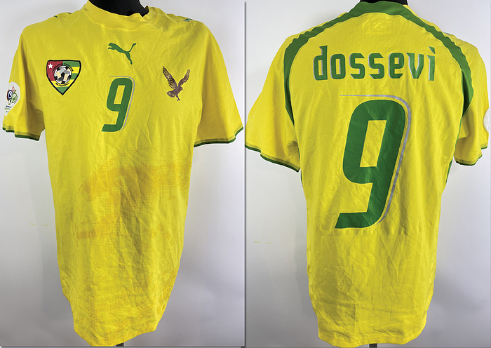  - Original match-issued Togo player shirt with number 9. Prepared for Thomas Dossevi for a match at the 2006 World Cup in Germany. The set consists of a jersey and shorts. Status ABC Short-sleeved shirt; size L; club emblem, Puma manufacturer logo glued on; rubberized player number and name; flocked 2006 World Cup patch; 100% polyester; Made in Thailand. Condition: A