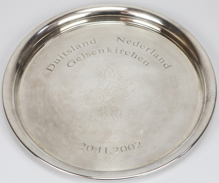  - Original commemorative plate from the Dutch Football Association (KNVB) celebrating the friendly match on November 20, 2002, in Gelsenkirchen (engraved) with the inscription "Germany - Netherlands" and the KNVB logo. Silver-plated, 29.5 cm --a gift of honor from the KNVB to a high-ranking German football official! --The piece comes directly from the estate of the high-ranking DFB official. Condition: A-