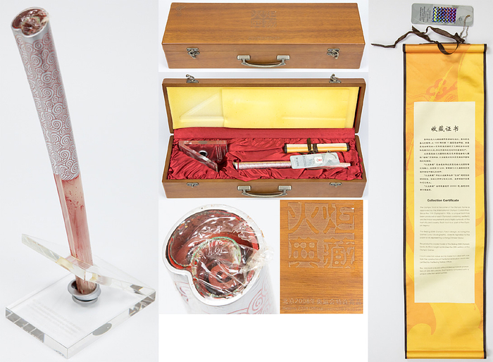 Olympiafackel 2008  | Original Miniaturfackel der Olympischen Spiele Peking 2008. Mit Aufsteller aus Glas mit Gravur und Aufschrift und Zertifikat. Aluminium, 29 cm hoch. In original Holzkassette (48,5x15x10 cm). Nummeriert, hier Nr. 027242/200000.