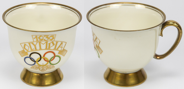 Porzellantasse 1936  | Porzellantasse mit Goldrand und mit farbigen Olympischen Motiven „1936 Olympia“ und den Olympischen Ringen. Hersteller: „Echt Tuppack. Tiefenfurt“ Tasse: 9x8,5 cm;.