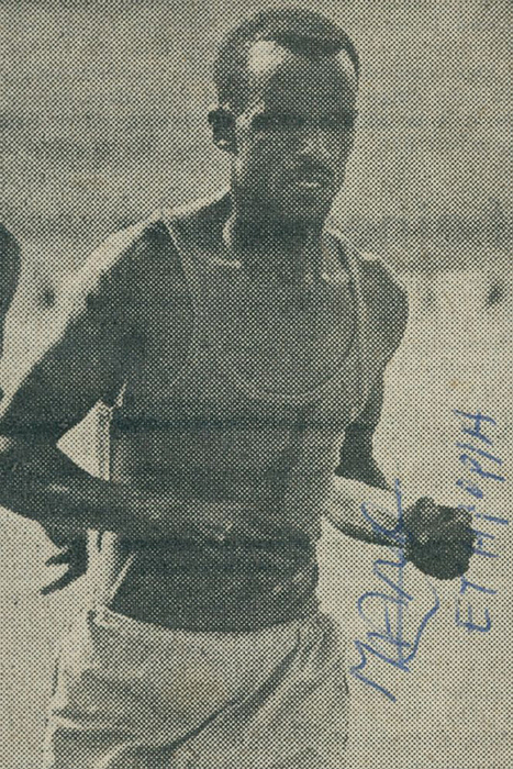 Wolde, Mamo  | (1932-2002) Zeitungsfoto mit original Signatur Mamo Wolde (ETH). 3facher Medaillengewinner bei den Olympischen Spielen 1968 (Gold Marathon + Silber 10.000m) und 1972 (Silber Marathon), 8,5x5,5 cm.