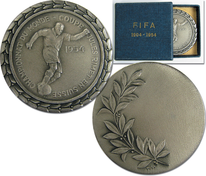 Boxed Participation Medal: World Cup 1954. - Silver plated medal given to players, assistants and referees. „Championnat du Monde - Coupe Jules Rimet en Suisse 1954“. Produced by "PEKA" Very rare! Size 4.2 cm. With original cardboard presentation box. 4.6 x 4.6 x 0.9 cm. Personal copy from Werner Liebrich! Condition: A-