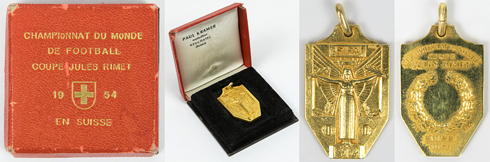 1Siegermedaille WM1954  | Offizielle Siegermedaille der FIFA für die deutsche Mannschaft für den 1.Platz bei der 5.Fußball-Weltmeisterschaft 1954 in der Schweiz. „Championat du Monde Coupe Jules Rimet Suisse 1954" Gold (gestempelt, 750er Gold.  Hersteller: "PEKA"), 3,6x2,3 cm. Im original Pappetui mit goldgeprägtem Deckel und Pappscharnier (5,5x5,5x1,4 cm). Persönliches Exemplar von Werner Liebrich. MUSEUMSSTÜCK!.