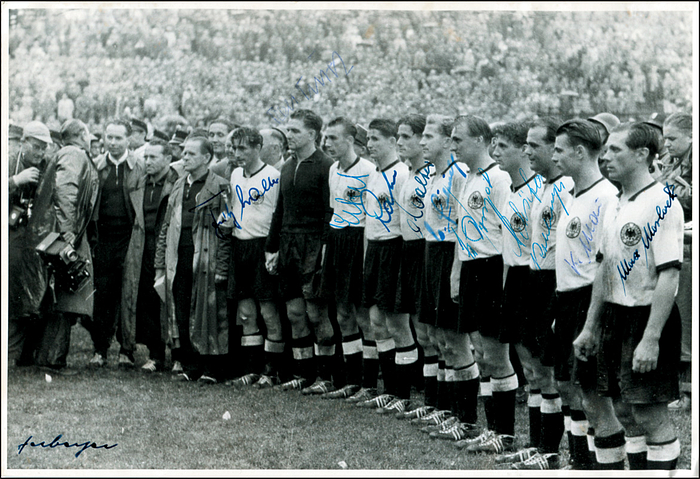 Weltmeister 1954  | S/W-Pressefoto des Fußball-Weltmeisters 1954 Deutschland bei der Siegerehrung der Fußball-Weltmeisterschaft 1954 nach dem Endspiel Deutschland v Ungarn (3:2) am 5.7.1954 in Bern. Mit 20 Originalsignaturen der deutschen Spieler und des Trainers. (F.Walter, Turek, Eckel, Rahn, O.Walter, Liebrich, Posipal, Schäfer, Mai, Morlock, Herberger, Erhardt, Laband, Metzner, Biesinger, Klodt, Kubsch, Kwiatkoski, Mebus, Pfaff). 18x13,5 cm.
