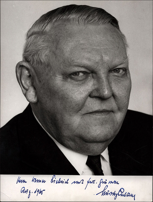 Erhardt, Ludwig  | (1897-1977) Großes S/W-Foto des ehemaligen Bundeskanzlers Ludwig Erhardt mit persönlicher datierter Widmung an Werner Liebrich "Aug.1965". 23x18 cm