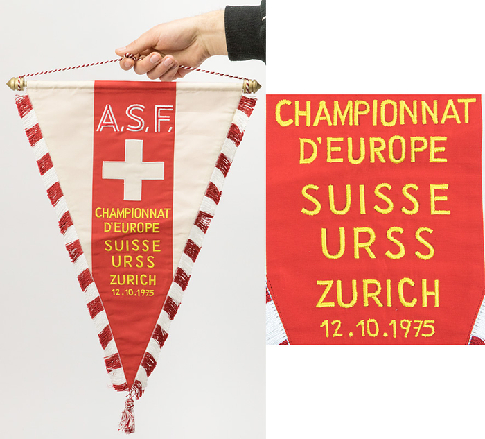  - Original match pennant of the Swiss national team from the football match between Switzerland and the USSR on October 12, 1975, in Zurich. Silk, embroidered with the match details: "Championnat d´Europe Suisse - URSS Zurich 12.10.1975." Features silk fringe, silk tassels, and a red-and-white hanging cord. Gilded wooden crossbar with finials. 46.5 x 32 cm (excluding tassels). --This match pennant was presented to the USSR, the referees, and the UEFA observers! From the collection of a UEFA observer. Condition: A-