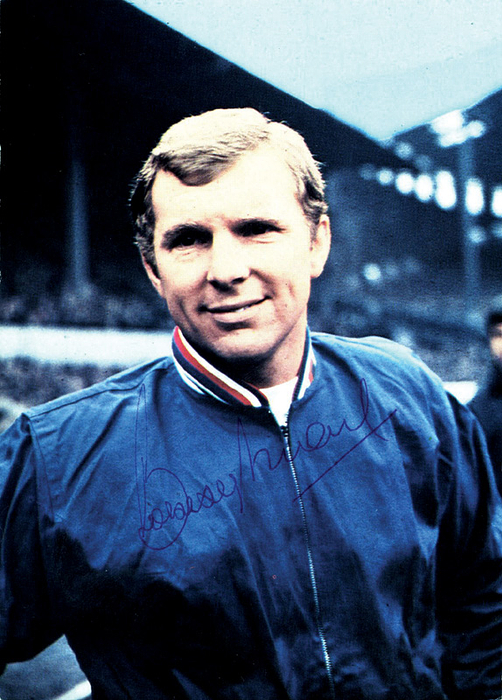 Moore, Bobby  | (1941-1993) Farbiges Bergmann-Sammelbild "Mexiko 70" mit Originalsignatur des englischen Weltmeisters 1966 Bobby Moore (108 LS).14,5x10,3 cm.