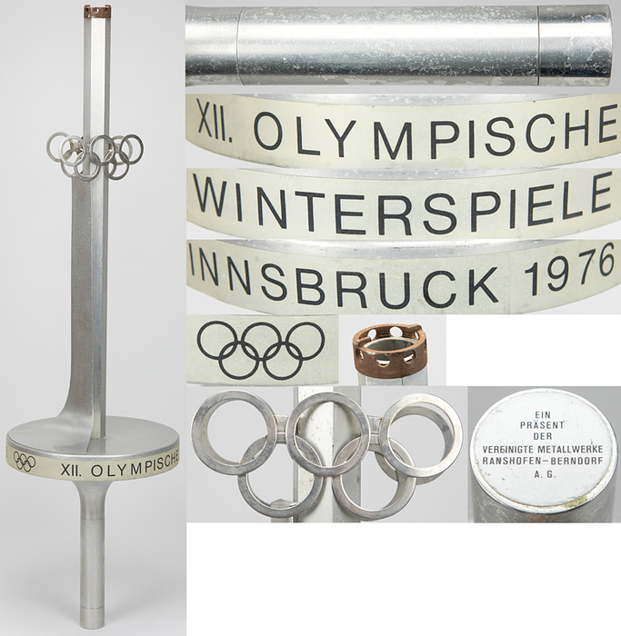 Olympiafackel 1976  | Original Fackel vom Staffel-Lauf mit dem Olympischen Feuer nach Innsbruck 1976. Aluminium und Edelstahl. Hersteller: Vereinigte Metallwerke Ranshofen-Berndorf AG. Länge: 74 cm. Durchmesser des Tellers: 21 cm.
