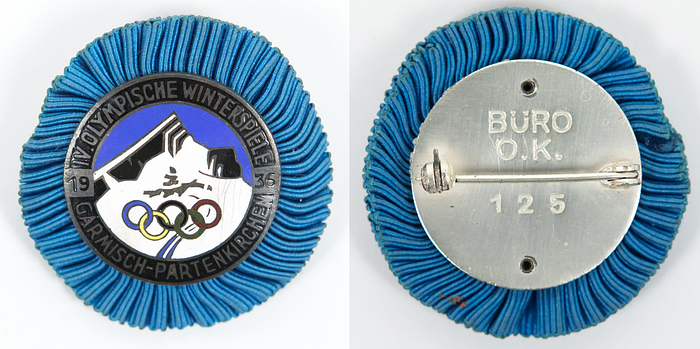  - 1936 Winter Olympic Games, Garmisch-Partenkirchen. Participant badge for members of the Organizing Committee. Silver-plated bronze. Multi-colored enamel; reverse engraved "Büro O.K. 125". With blue fabric rosette. 4 x 3.5 cm. --Ebel-W-008 — Extremely Fine (EF). Rarity!!! Condition: A